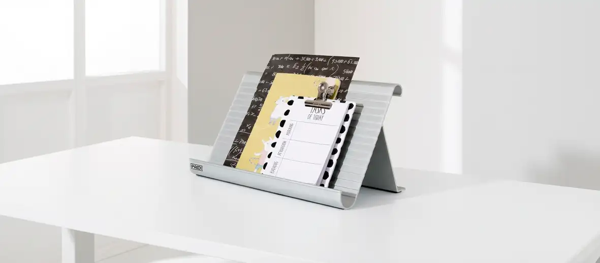 Buchstütze mit Notizblöcken auf weißem Schreibtisch