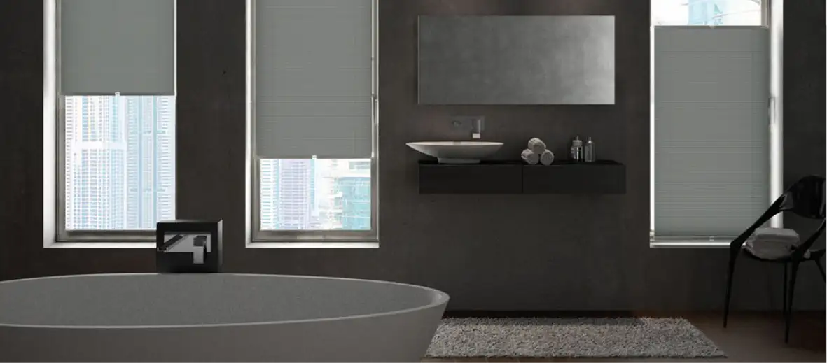 Plissees vor großen Fenstern in Badezimmer mit Badewanne davor. Dunkle Wand und Plissees halb geschlossen