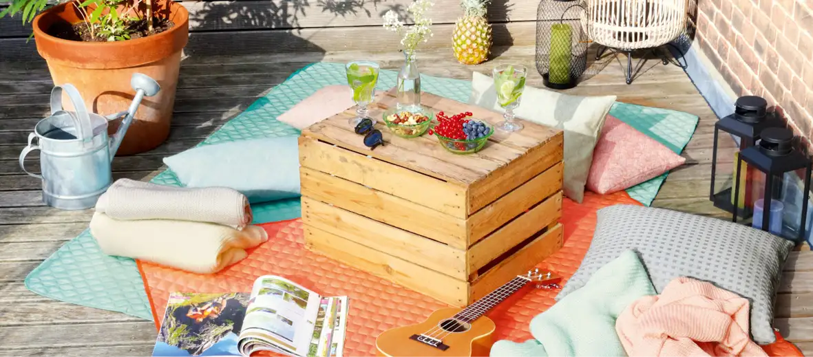 Picknickdecken auf Terrasse in blau und orange mit Tisch und Picknick