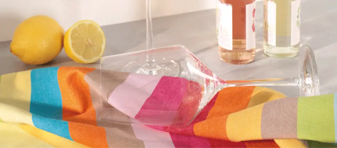 Bunt gestreiftes Geschirrtuch darauf Weinglas liegend