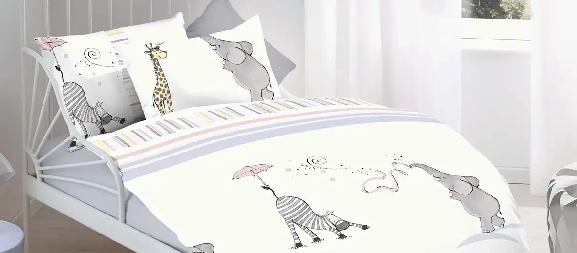 Kinderbettwäsche mit Zebra, Giraffe und Elefant in weiß. Auf einem Bett liegend